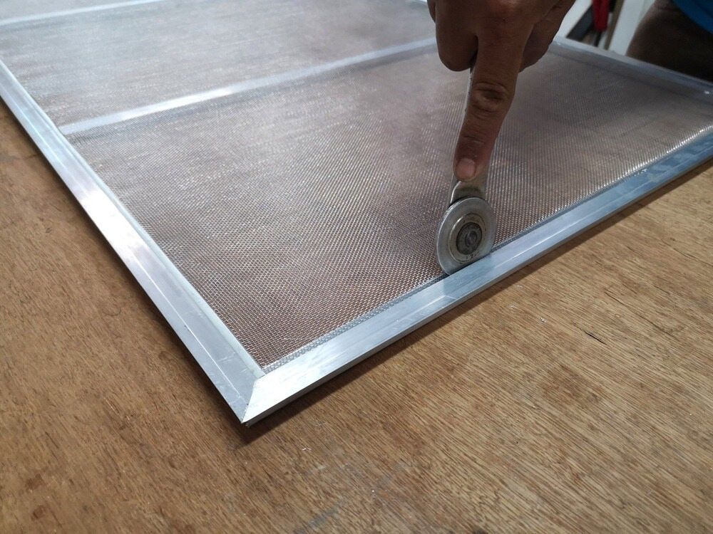 A Person is Using a Roller on a Window Screen — Kincumber Glass & Glazing in Kincumber, NSW