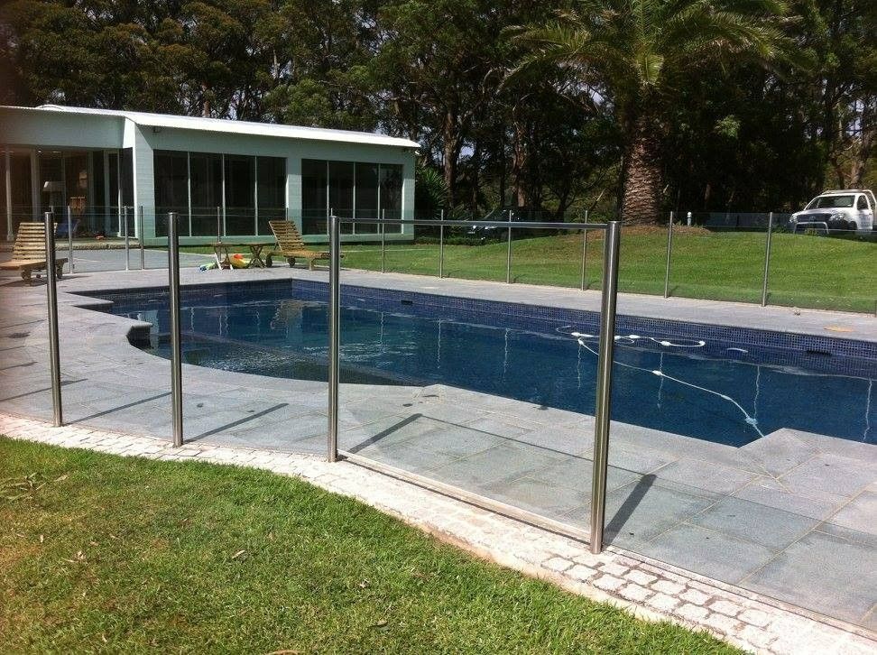 A Large Swimming Pool With a Fence Around It — Kincumber Glass & Glazing in Kincumber, NSW