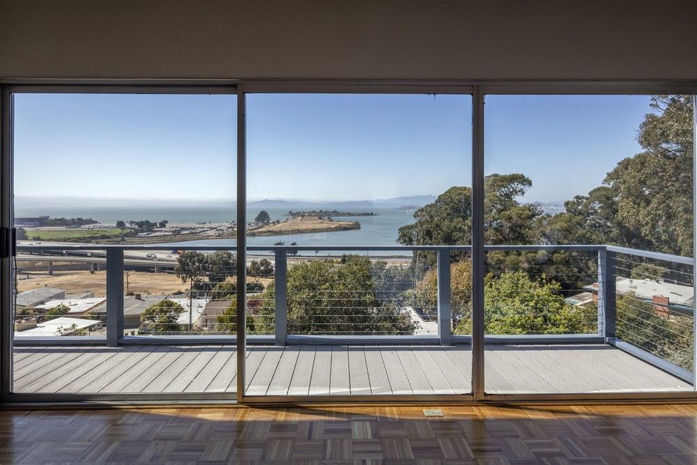 An Empty Room With a View of the Ocean Through a Sliding Glass Door — Kincumber Glass & Glazing in Kincumber, NSW