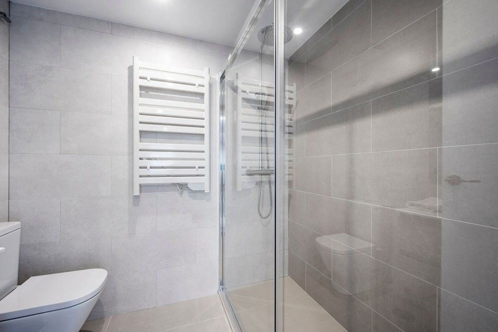 A Bathroom With a Toilet , Shower , and Towel Rack — Kincumber Glass & Glazing in Kincumber, NSW