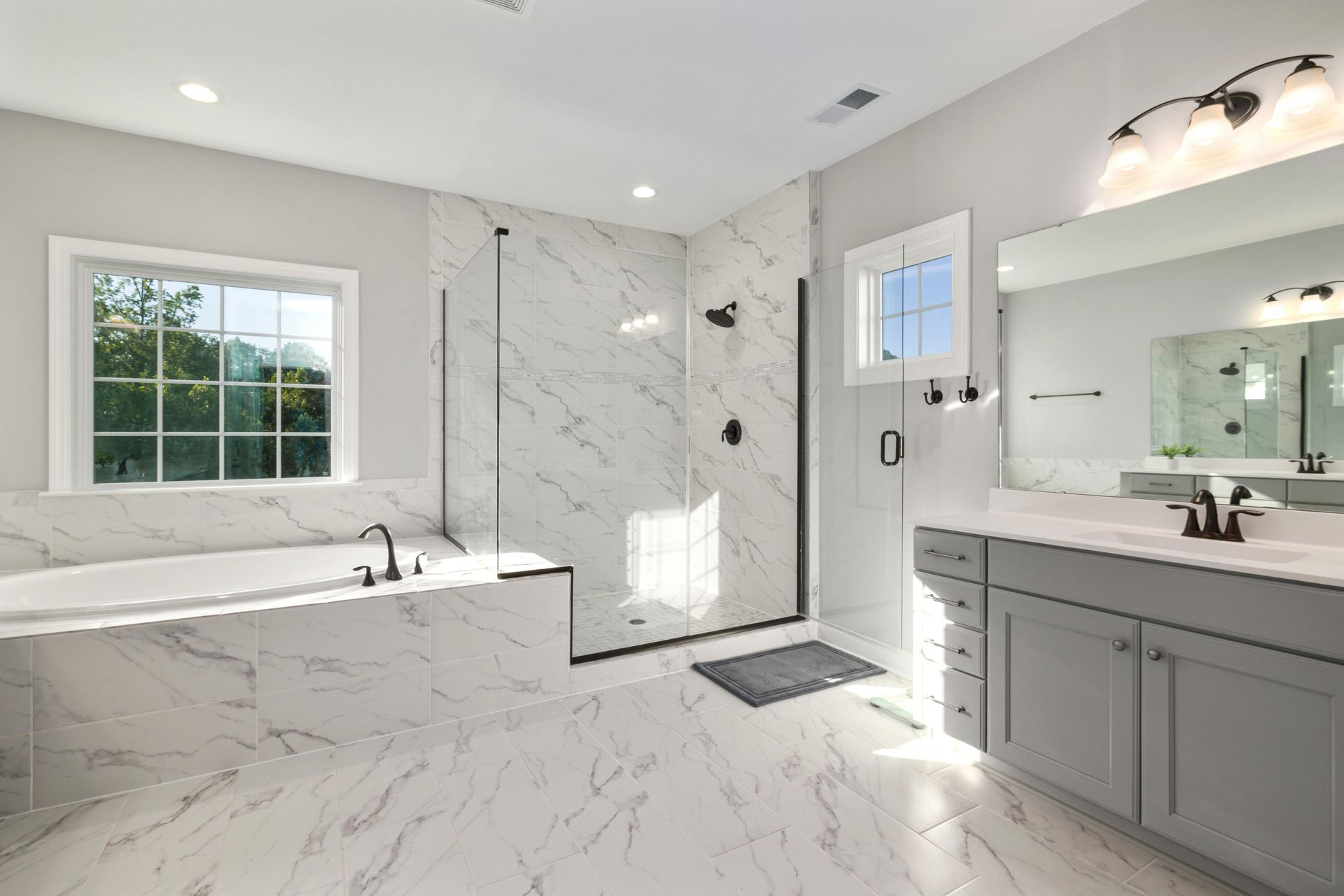 Spacious modern bathroom with white marble, a soaking tub, and glass shower. — Kincumber Glass & Glazing in Kincumber, NSW