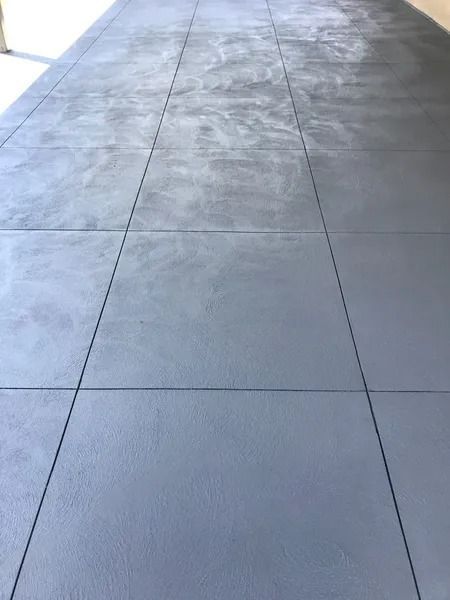 Gray concrete floor with grid lines, outdoors in natural light.