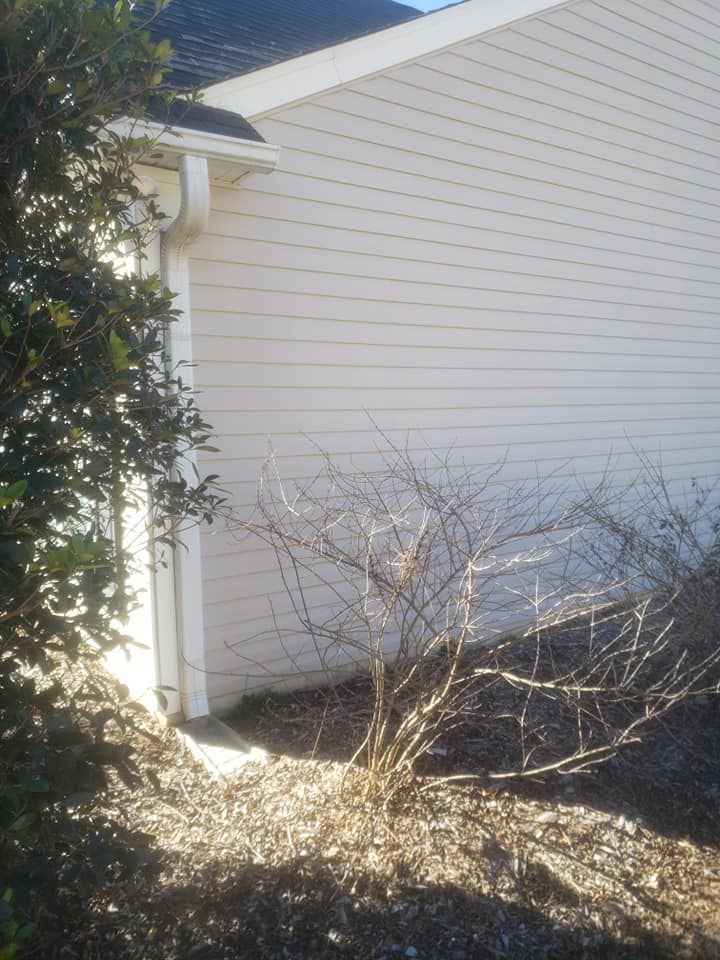 A white house with a gutter on the side of it