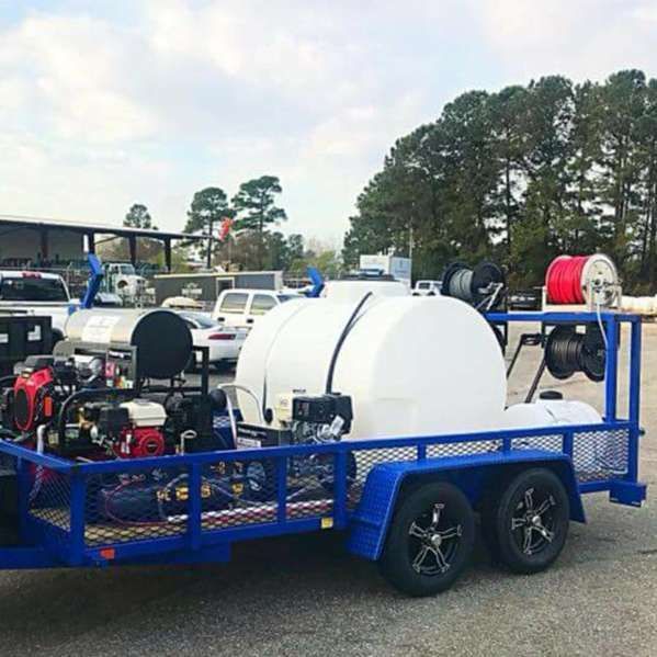 A blue trailer with a white tank on it is parked in a parking lot.