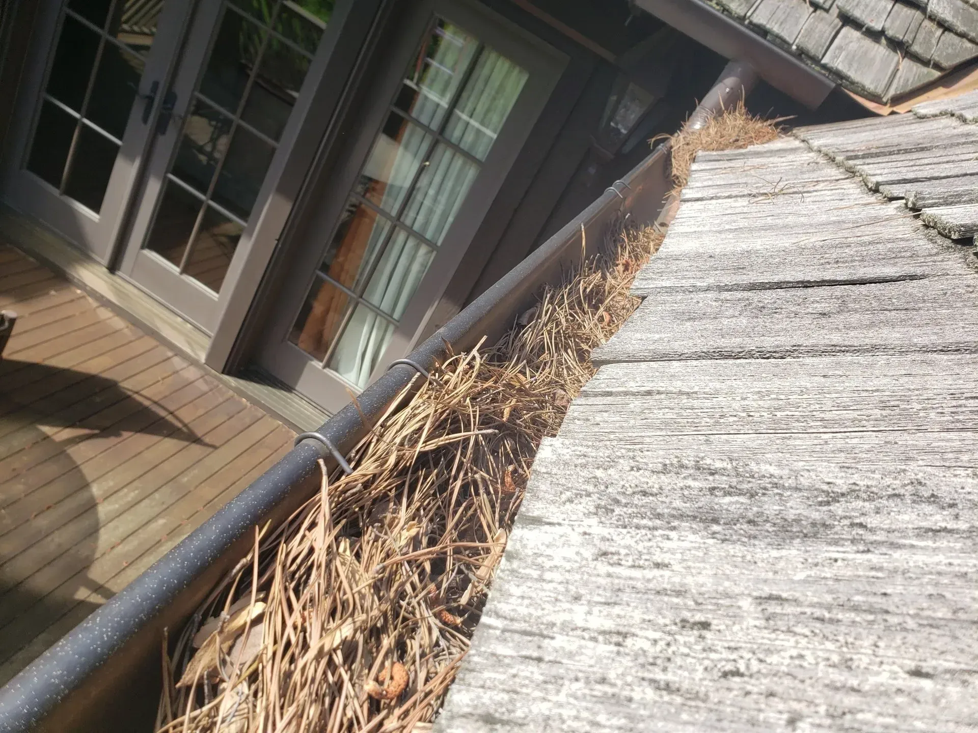 A gutter with a lot of dry grass on it