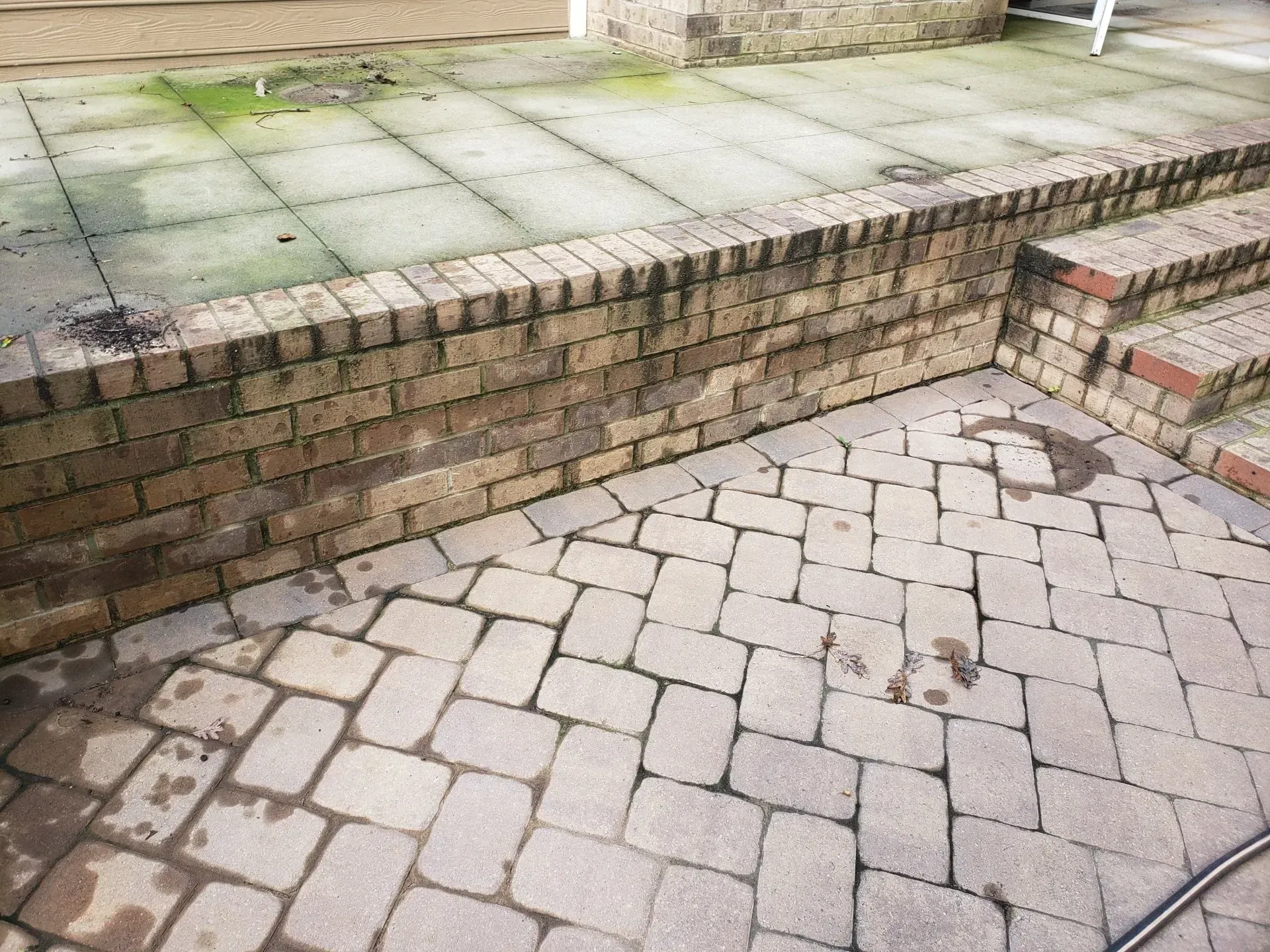 A brick walkway with steps and a brick wall.