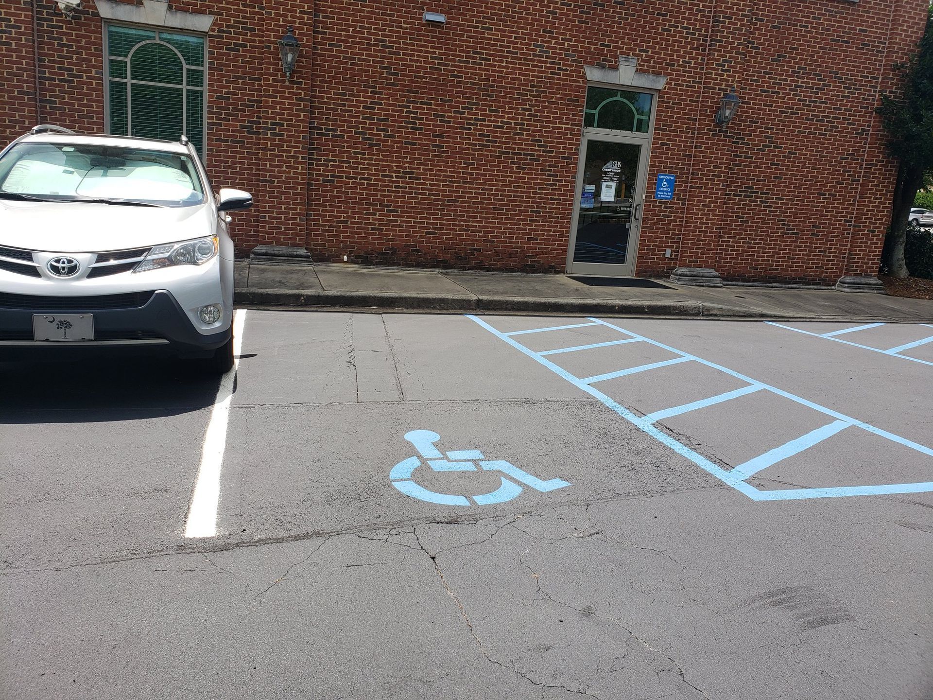 A white car is parked in a handicapped parking spot