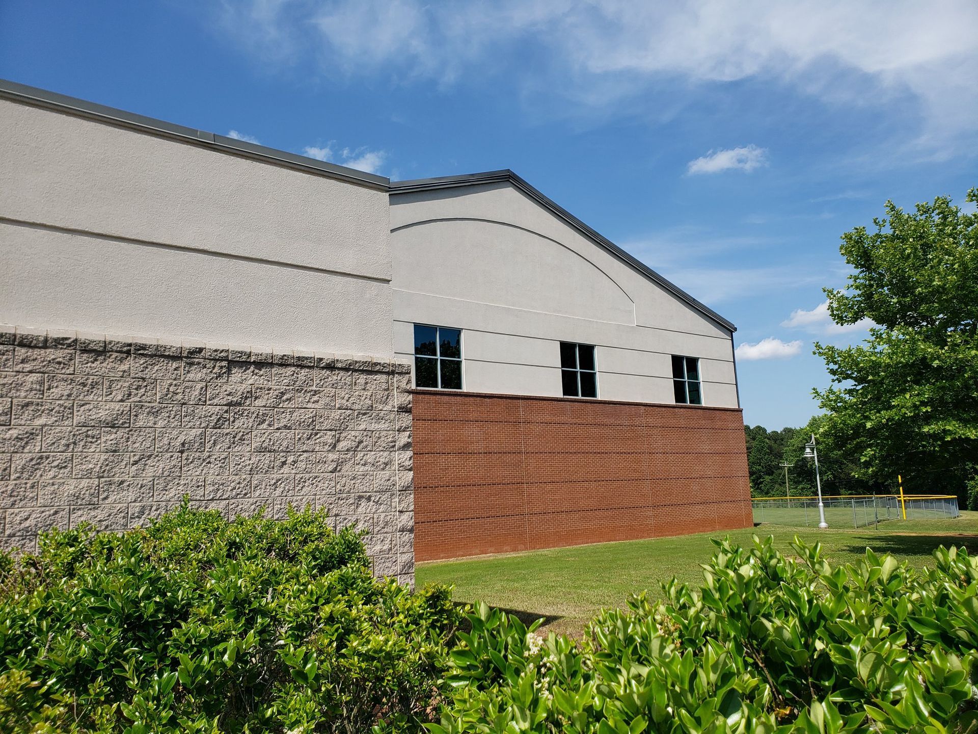 A large building with a brick wall and a white roof