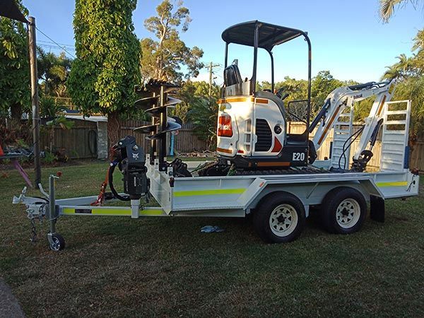 A small excavator on a trailer with the number 131 on it