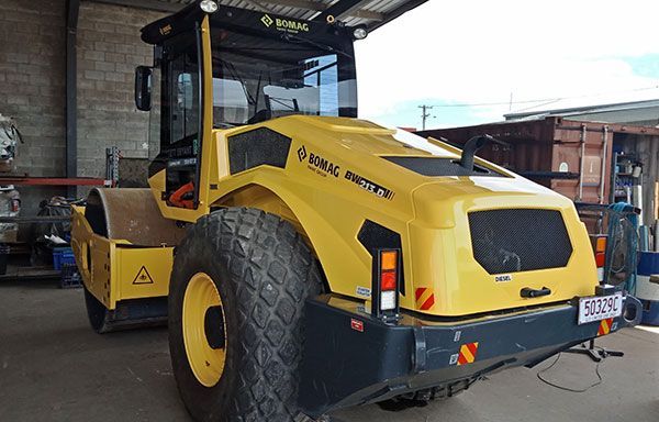 A yellow and black tractor is parked in a garage.