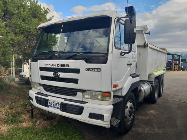 A white dump truck is parked in a parking lot.