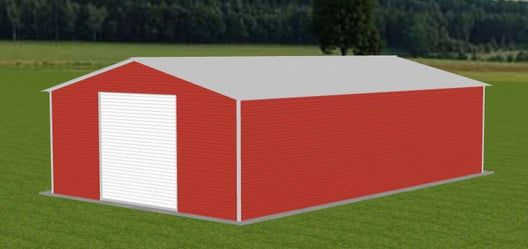 Red barn with a white garage door, gray roof, and green field backdrop.