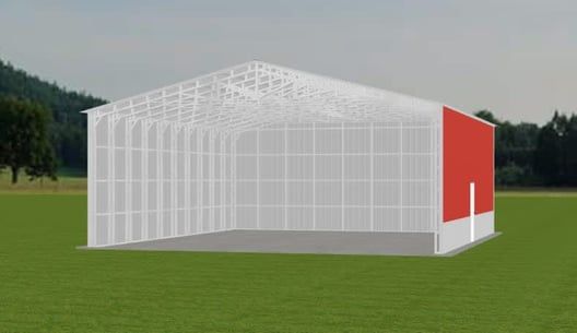 White metal framed building with red wall. Set on green grass under blue sky.