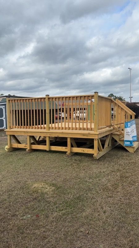 Gray shed with black doors and white-framed windows, against a gray sky.