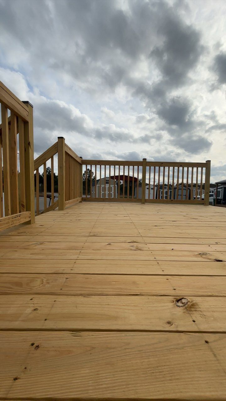 Truck towing a red shed with an open cargo door on a sunny road.