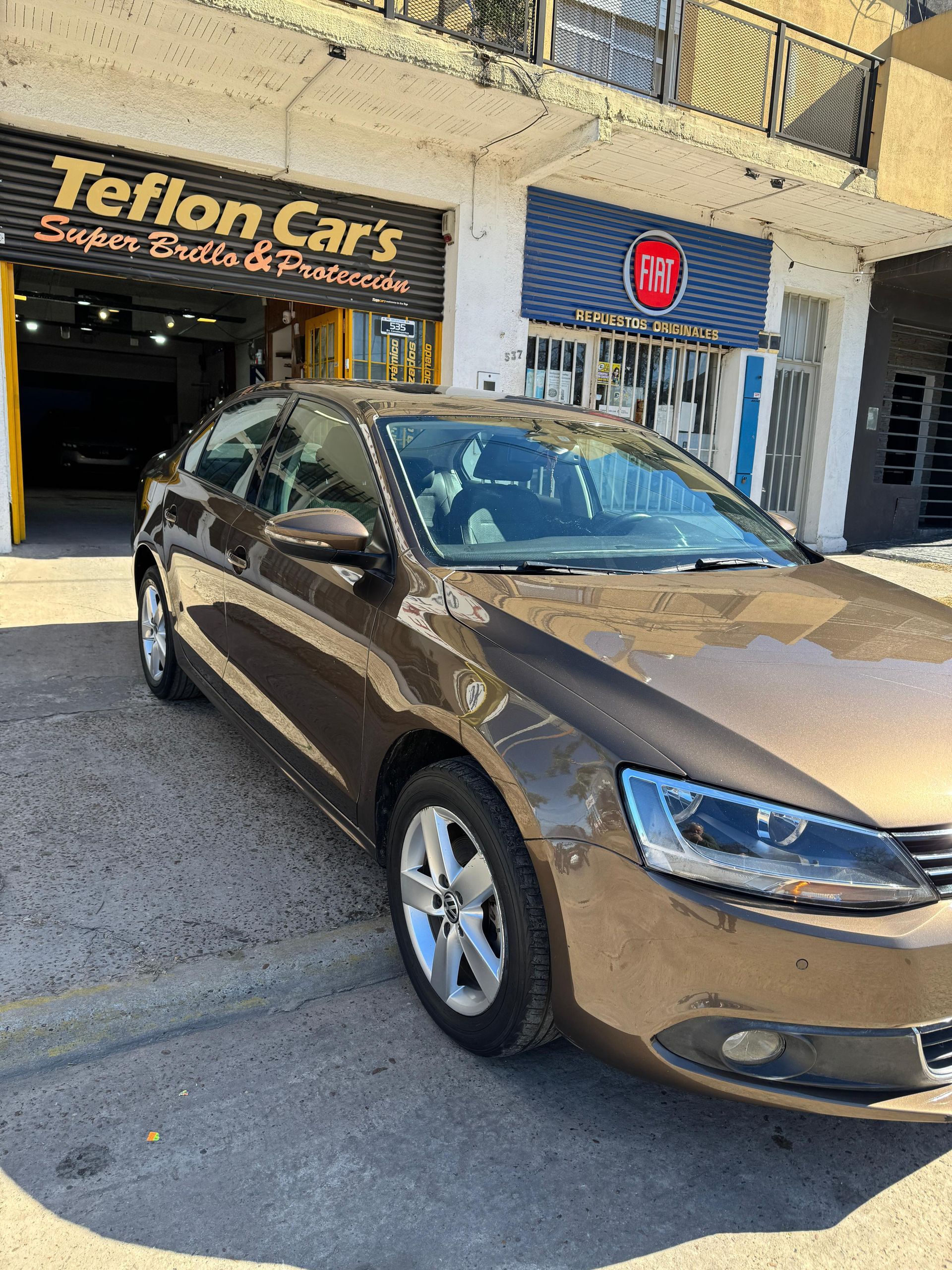 Sedán marrón estacionado afuera del taller de detallado