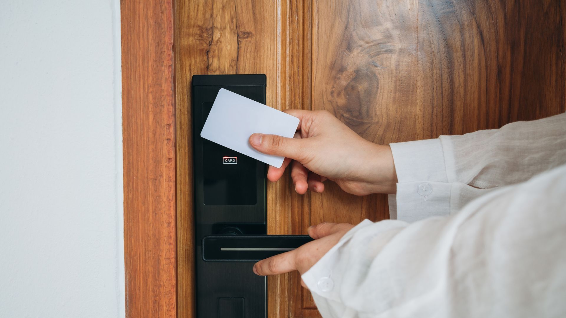 A person is using a key card to open a door.