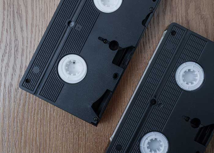 Video tape transfer image, two video cassettes facedown on a wood surface