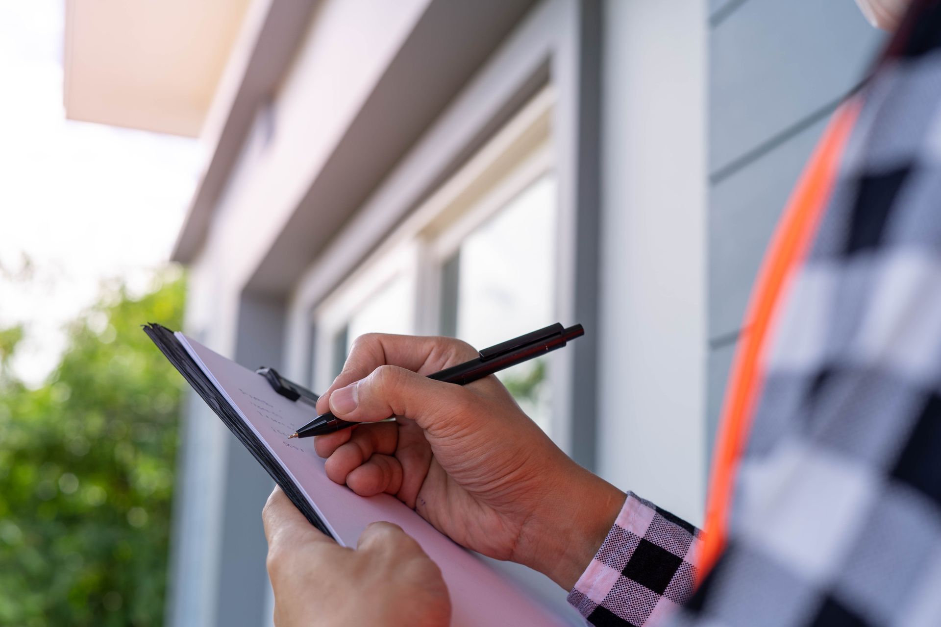 A man is writing on a clipboard with a pen.