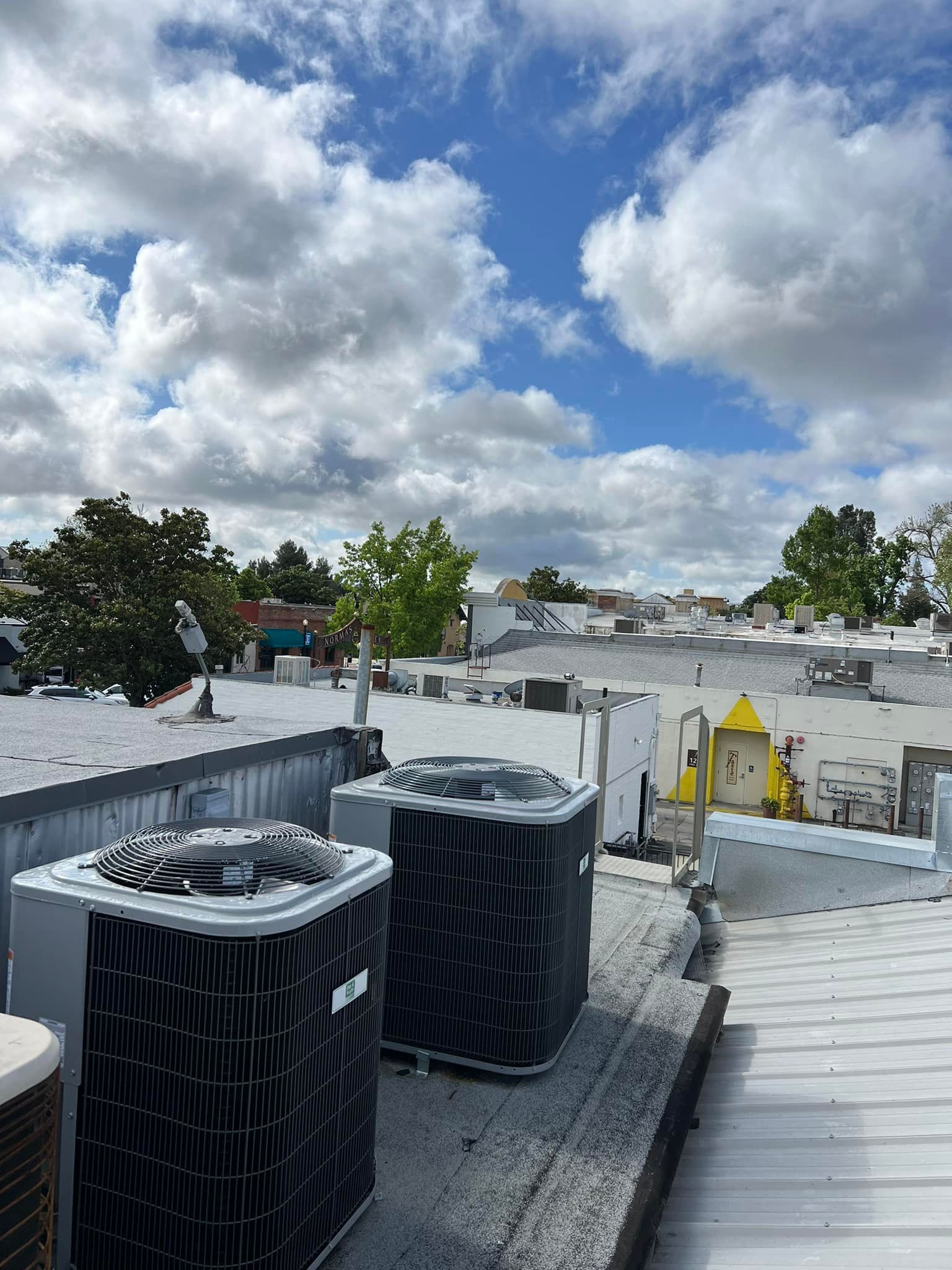 There are two air conditioners on the roof of a building.