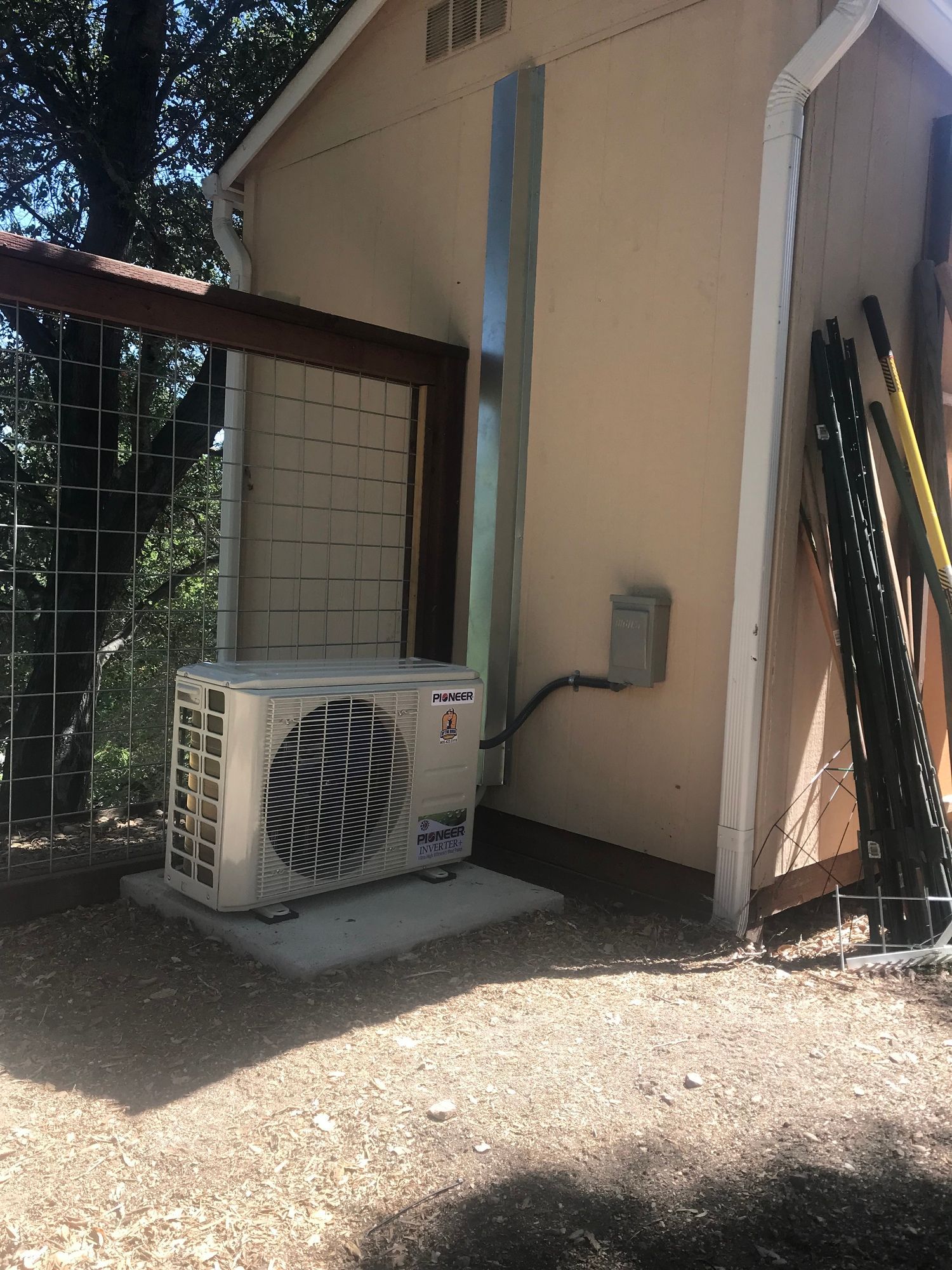 A white air conditioner is sitting on the side of a building.