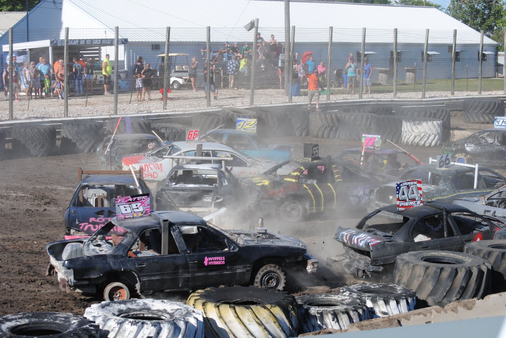 A group of cars are racing on a dirt track.
