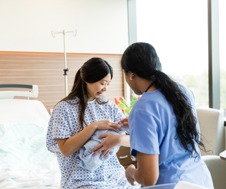 A newborn baby is being examined by a doctor in an incubator.