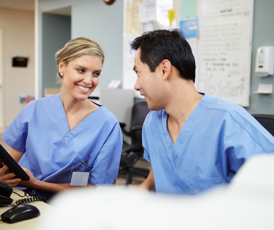 A nurse wearing a mask and gloves is standing in front of a group of doctors.
