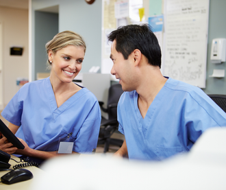 A female doctor is smiling while holding a stethoscope.