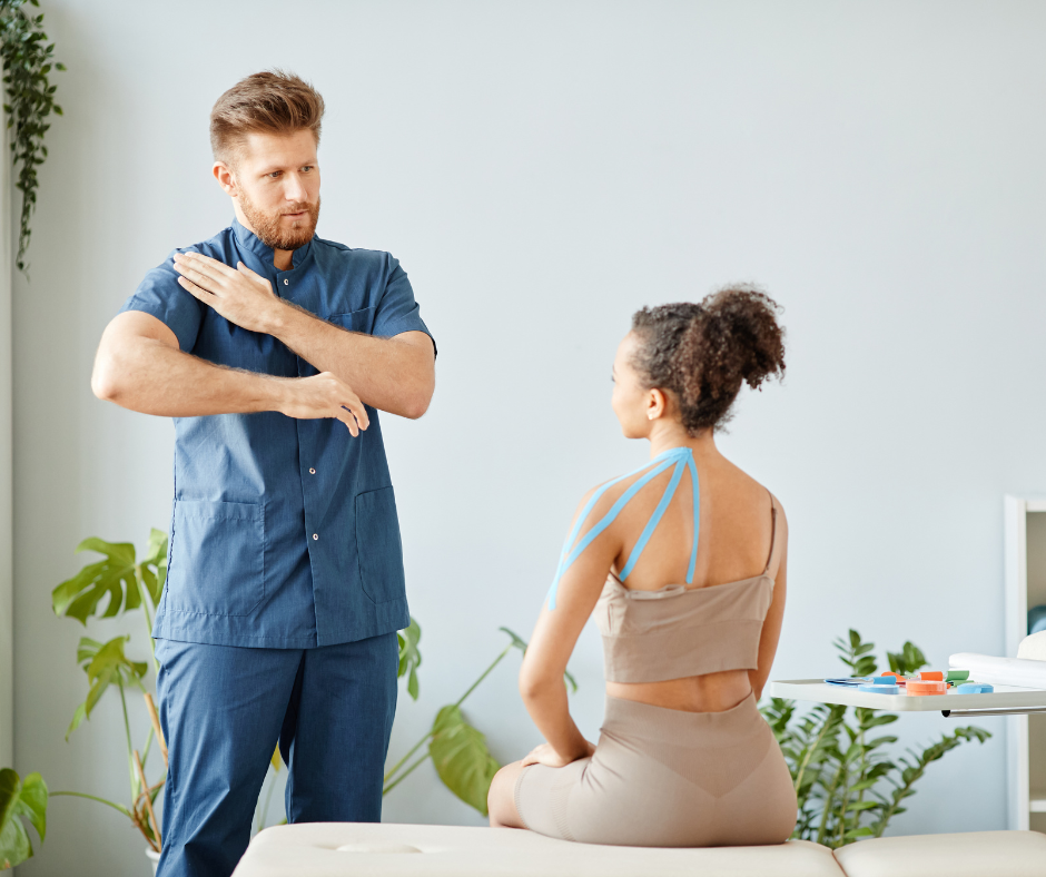 A nurse is smiling while sitting at a desk in front of a computer.
