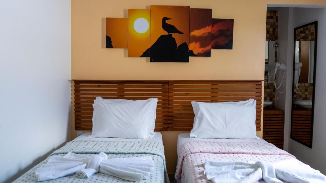 Um quarto com duas camas e uma pintura na parede