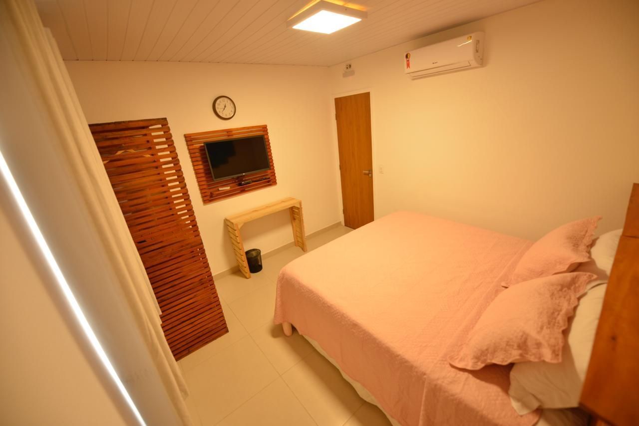 Um quarto com uma cama e uma televisão na parede.