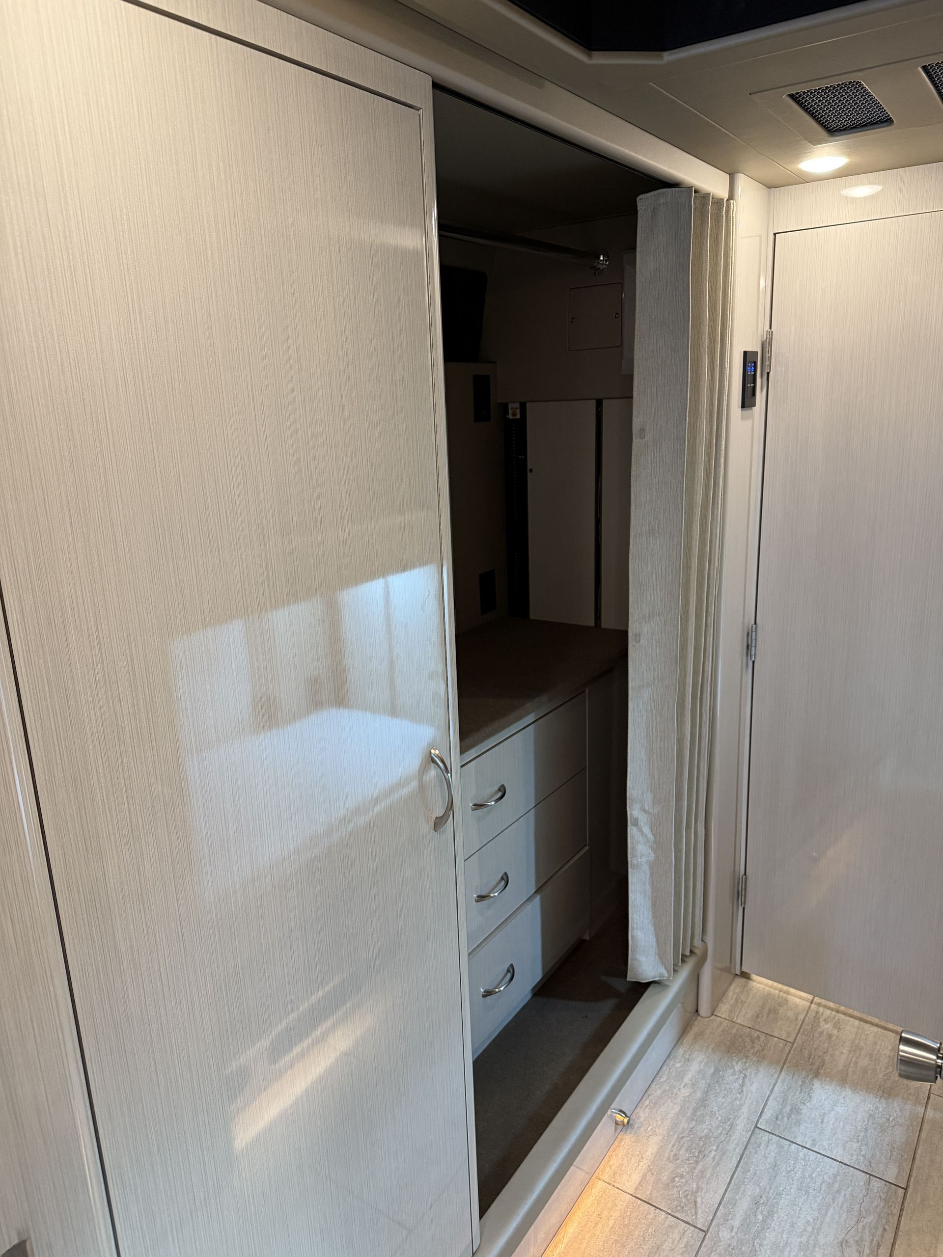 Dining area inside coach with table seating and overhead storage