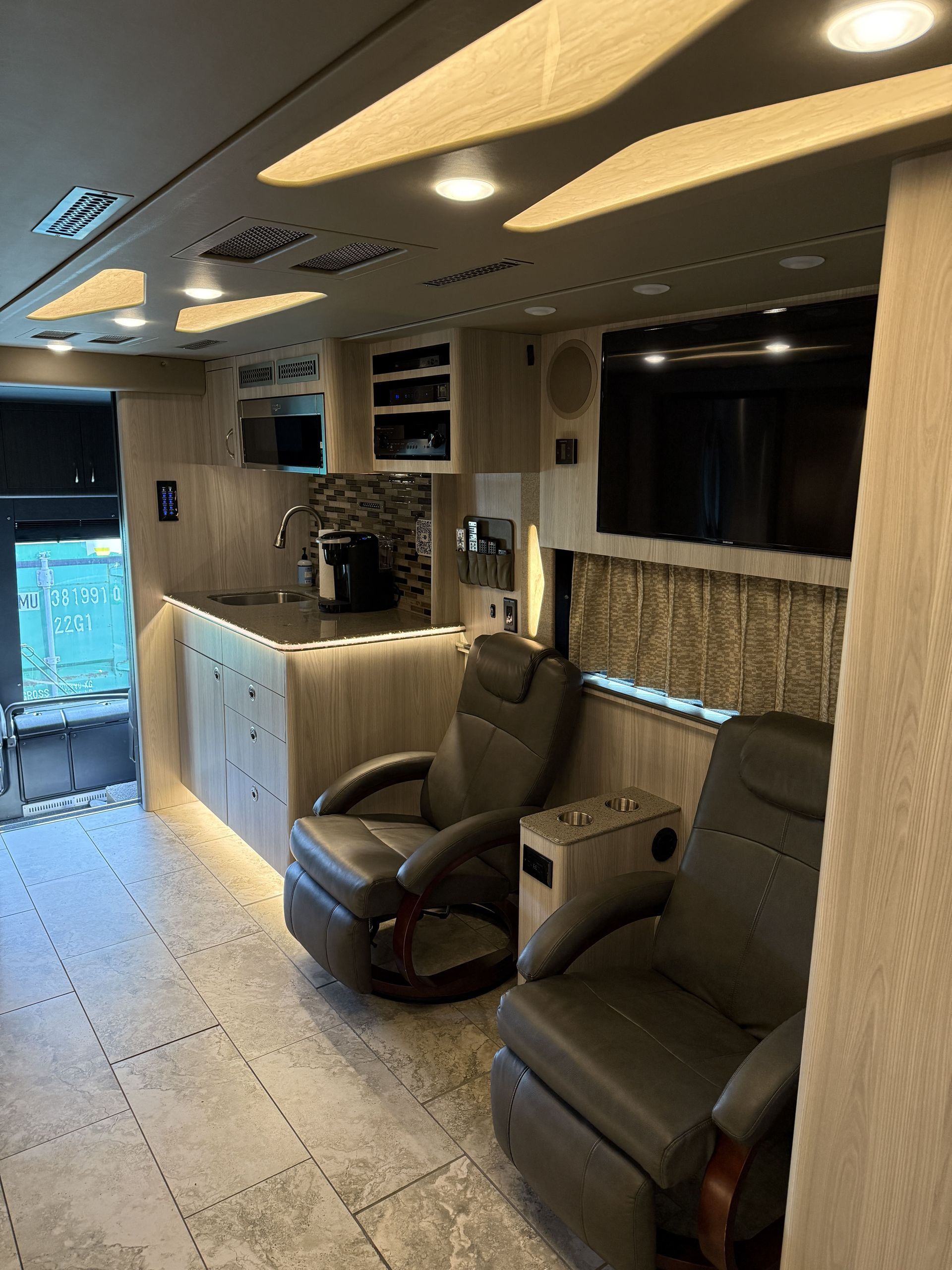 Dining area inside coach with table seating and overhead storage