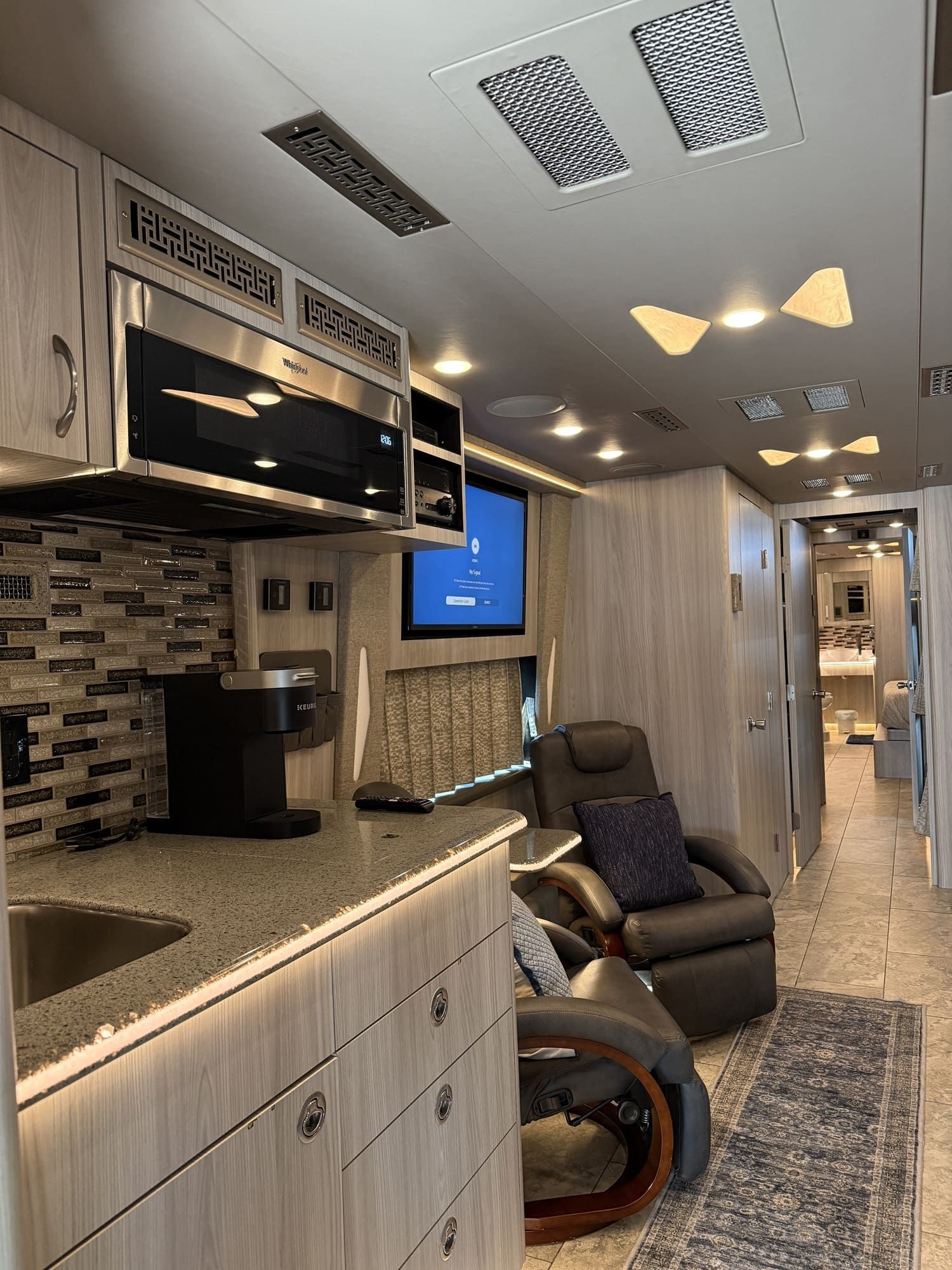 Spacious interior lounge of Coach 20 featuring premium seating and ambient lighting
