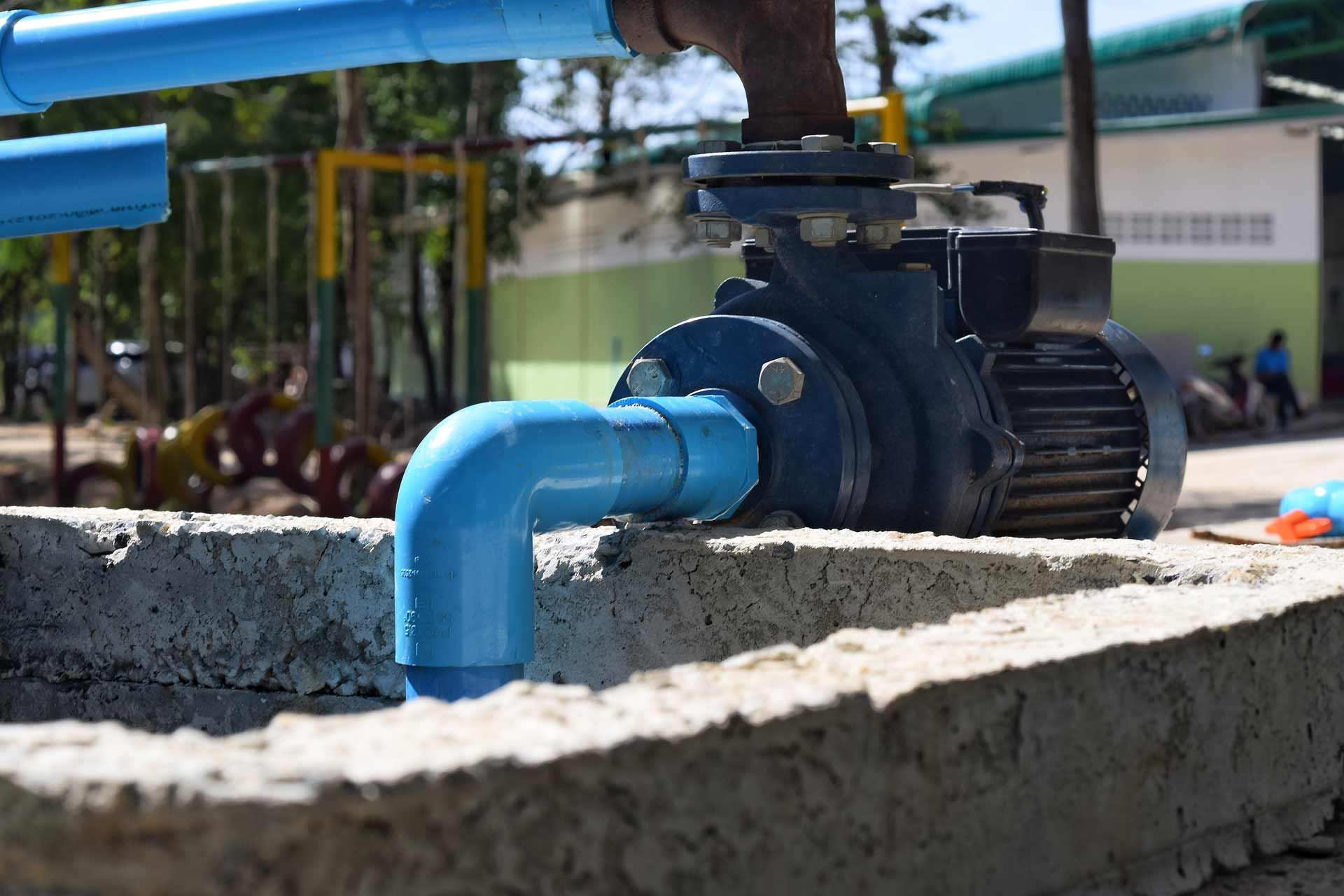 Blue water pump installed on a concrete base