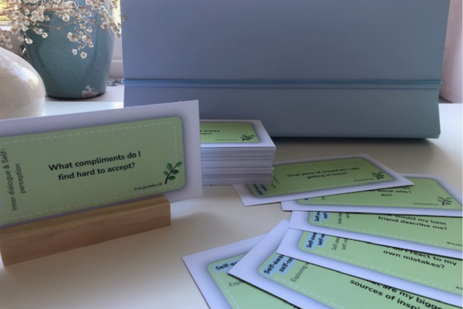 A stack of coach cards with one that says what compliments do i find hard to answer