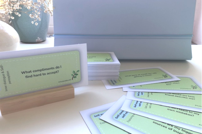 A card is sitting on a wooden stand next to a vase of flowers.