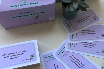 A box of coach cards with a plant in the background