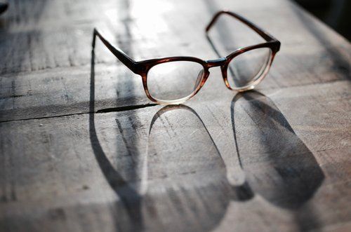 occhiali da lettura su sfondo legno