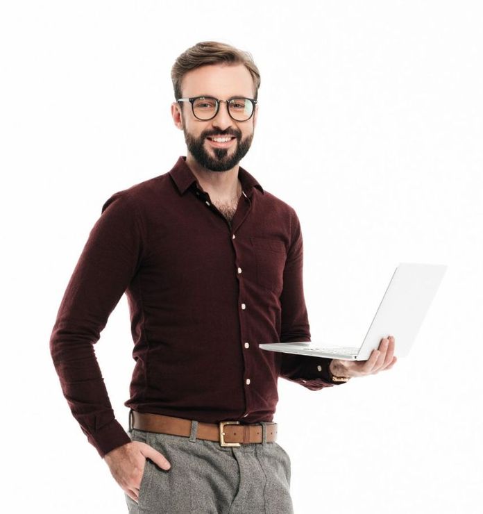 A man in a maroon shirt is holding a laptop