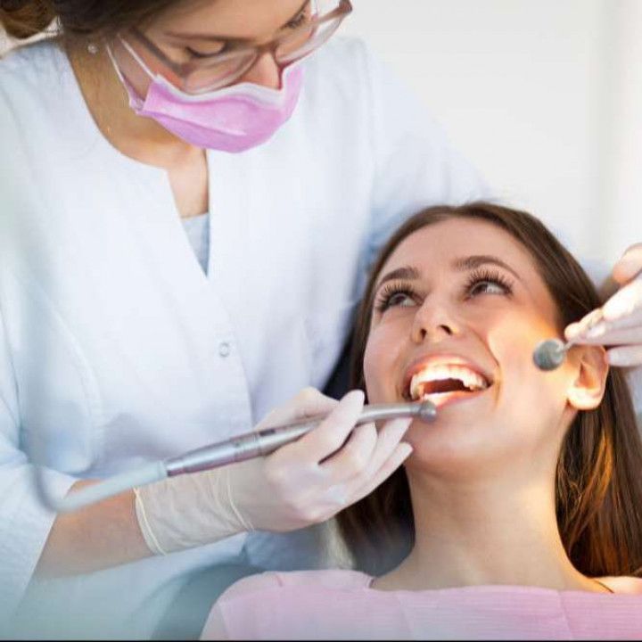 A woman is getting her teeth examined by a dentist