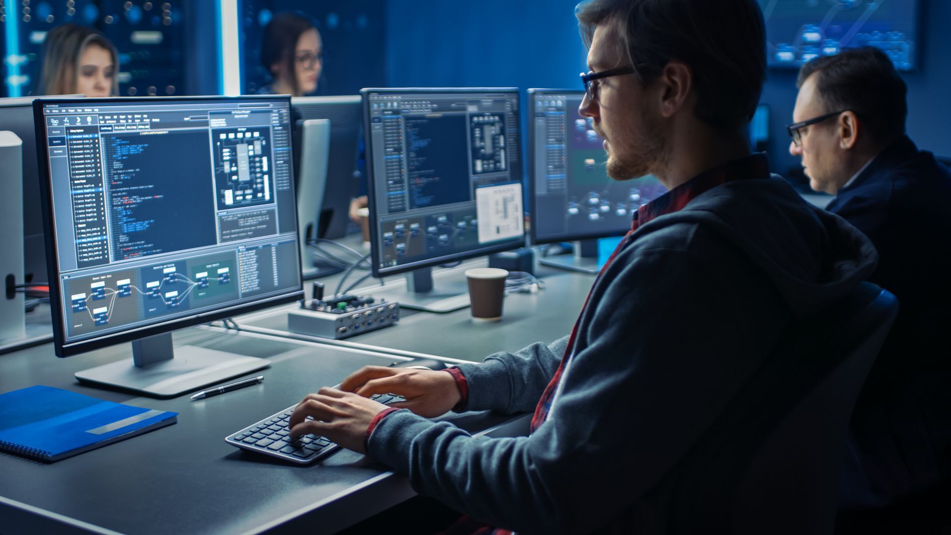 A man is sitting at a desk in front of a computer.