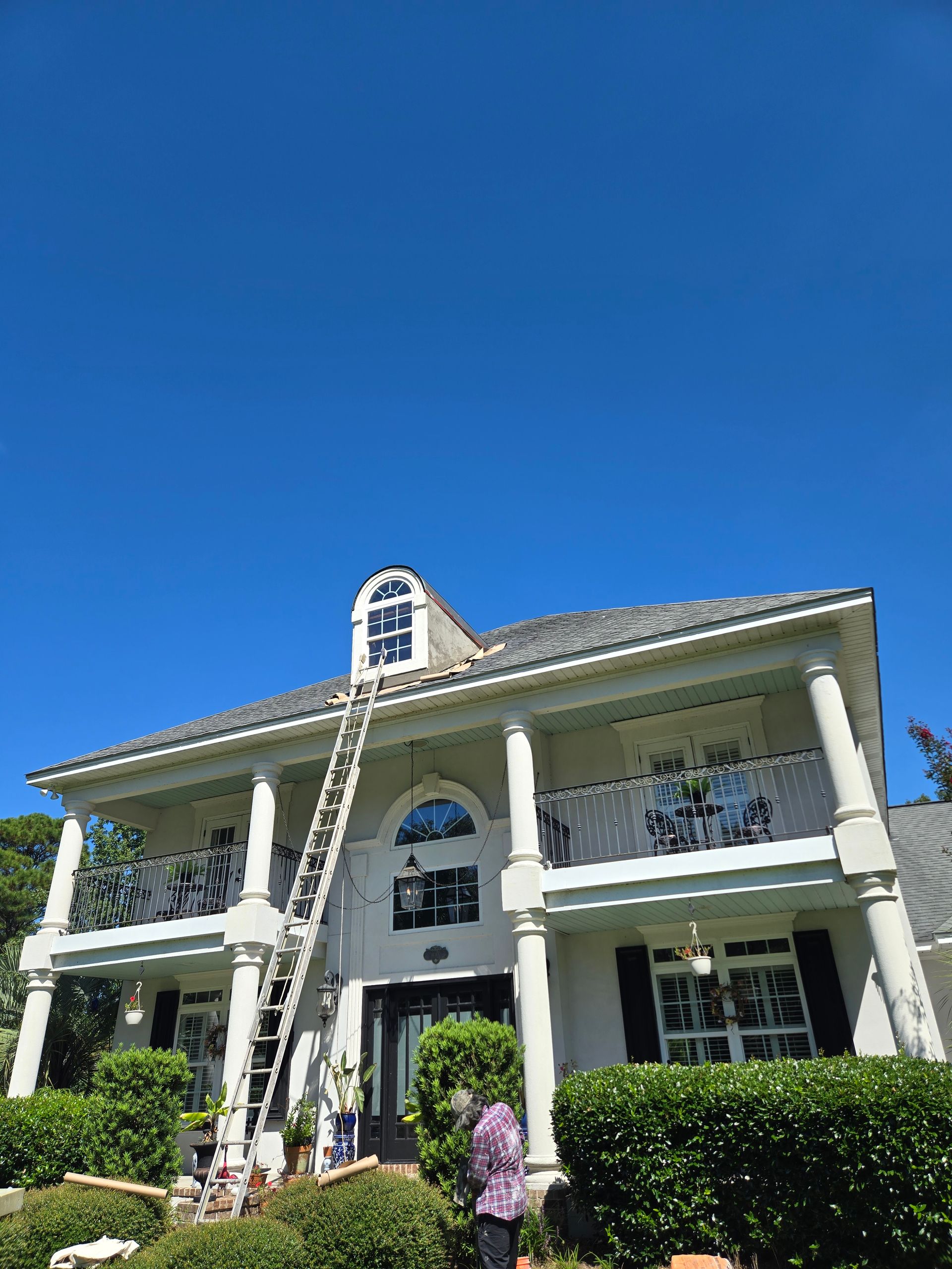 A man is kneeling down and painting a wall with a roller.
