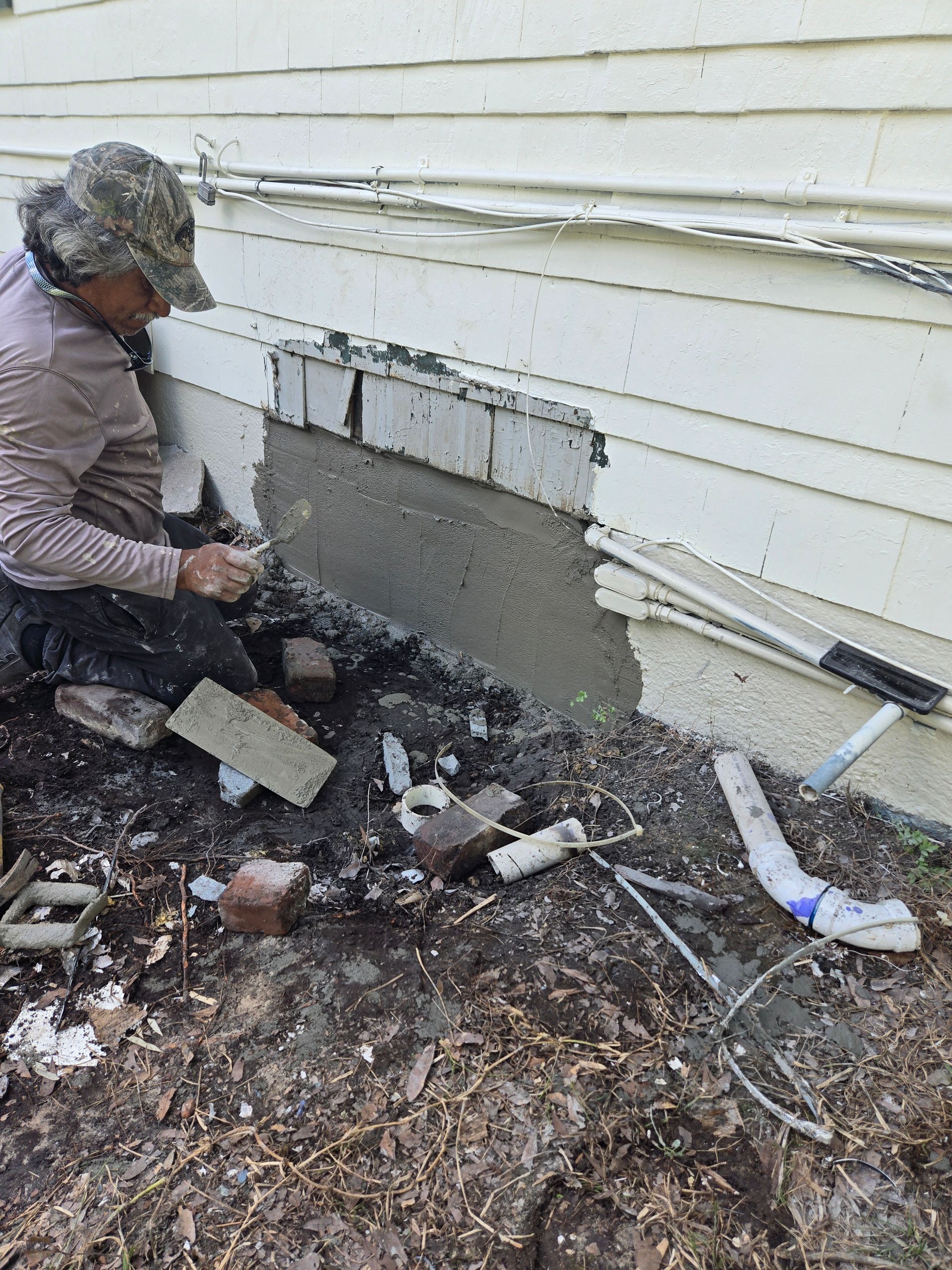 A man is painting a wall with a paint roller.