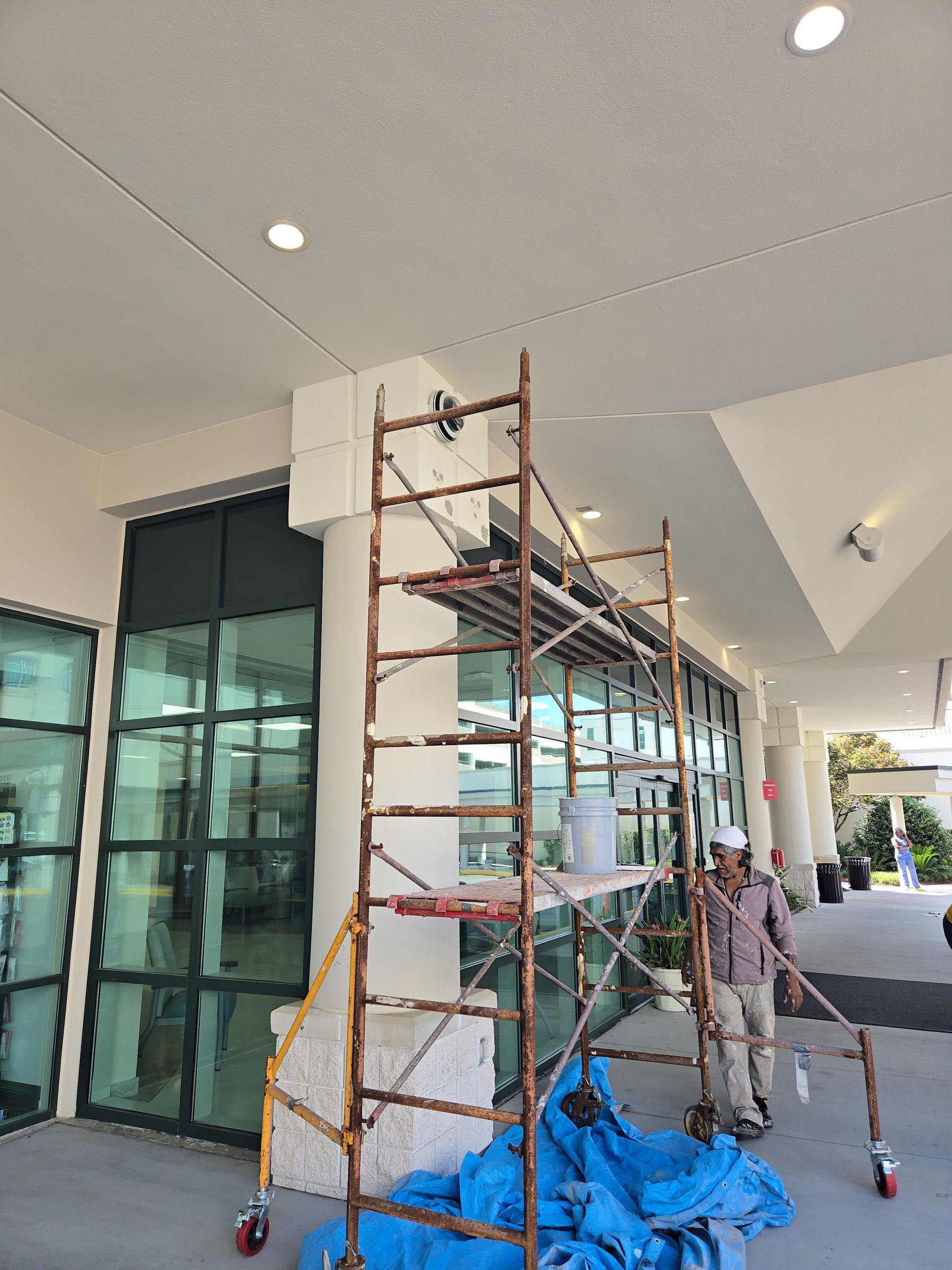 A man is painting a wall with a paint roller.