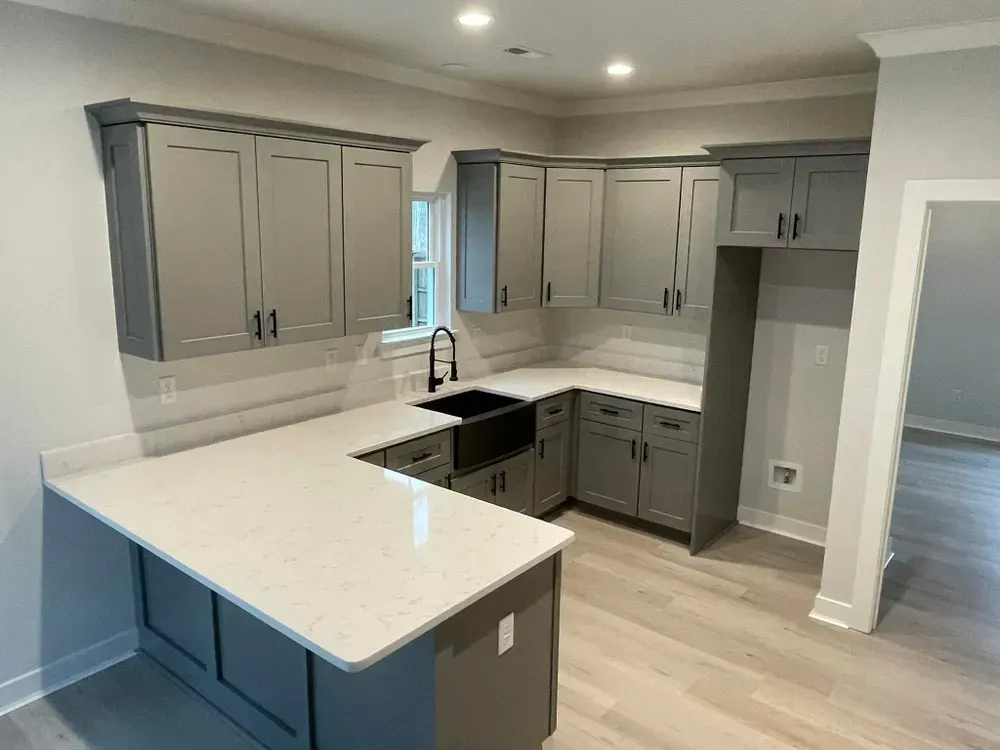 Modern gray-and-white kitchen with island, black sink, and light wood flooring