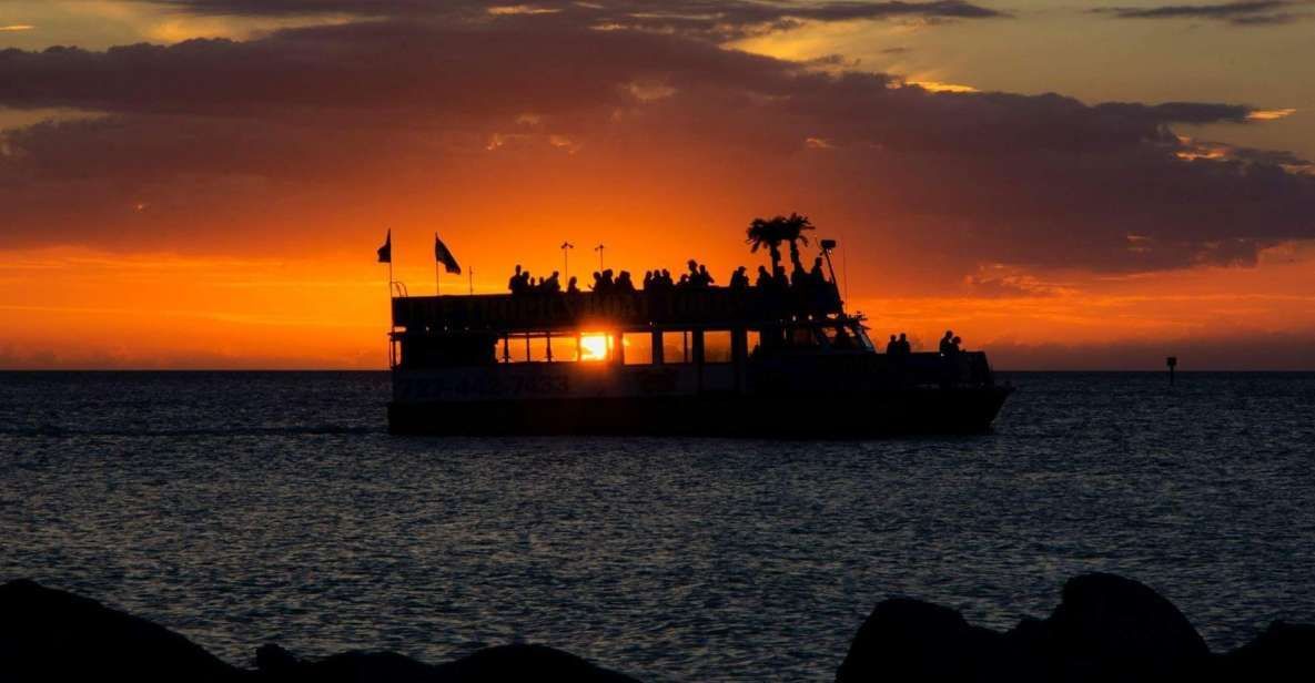 A boat is floating on top of a body of water at sunset.