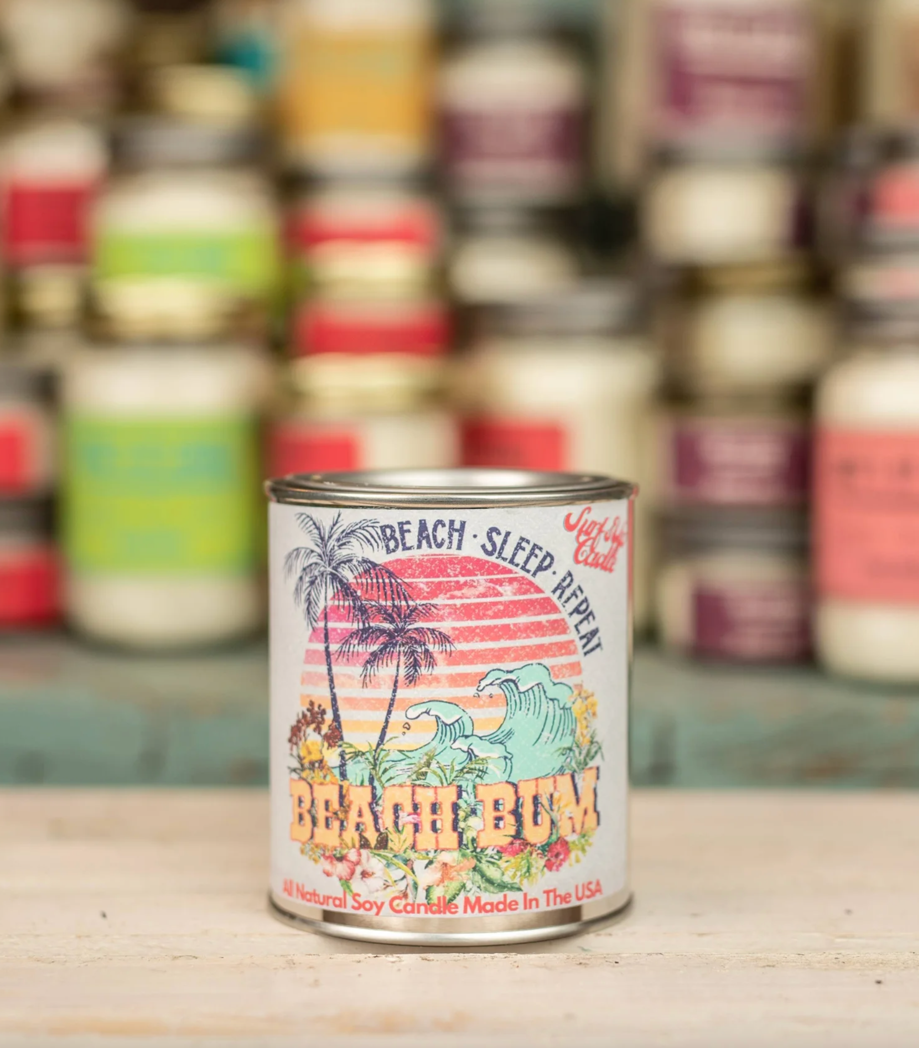 A can of beach bum candle is sitting on a wooden table.