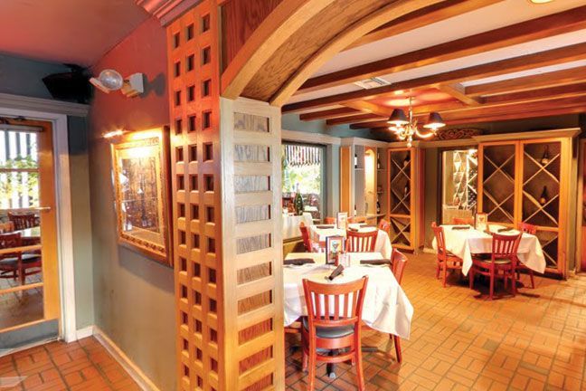 A restaurant with tables and chairs and a wooden wall